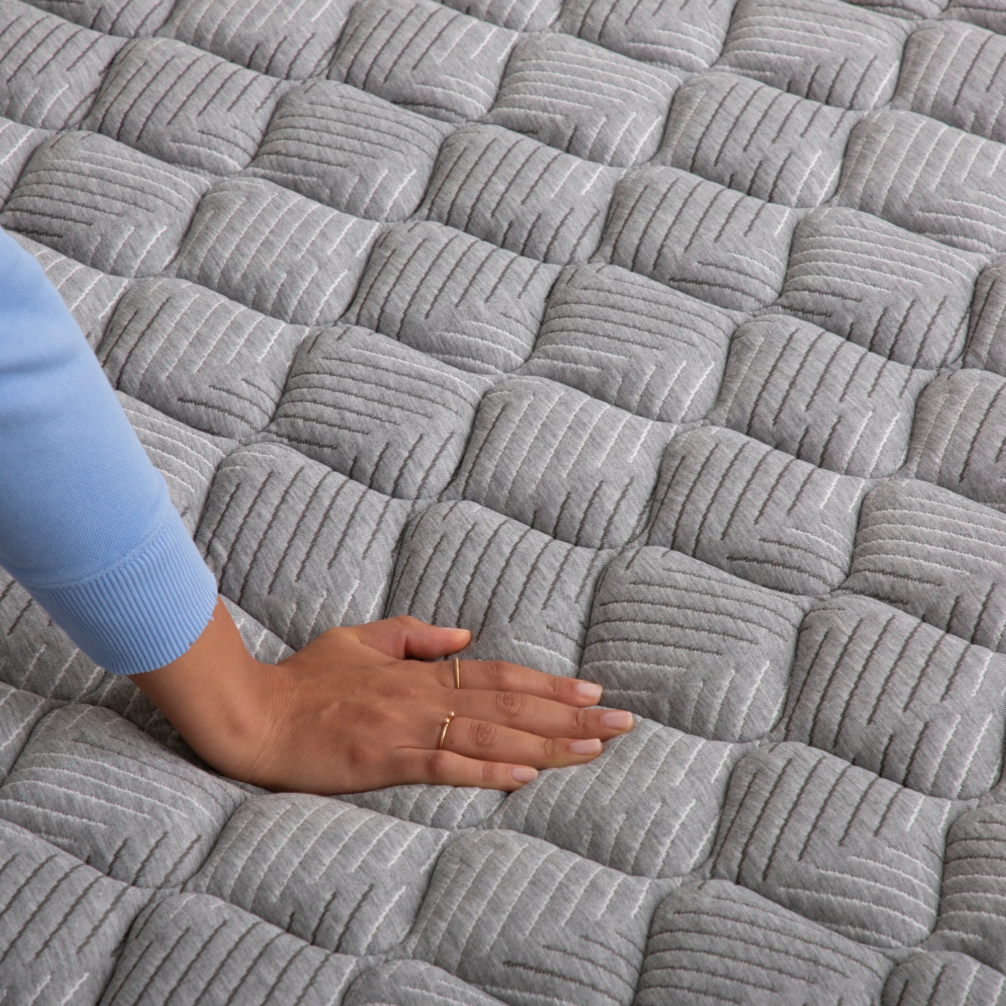 Hand pressing down on Quilted Firm Mattress