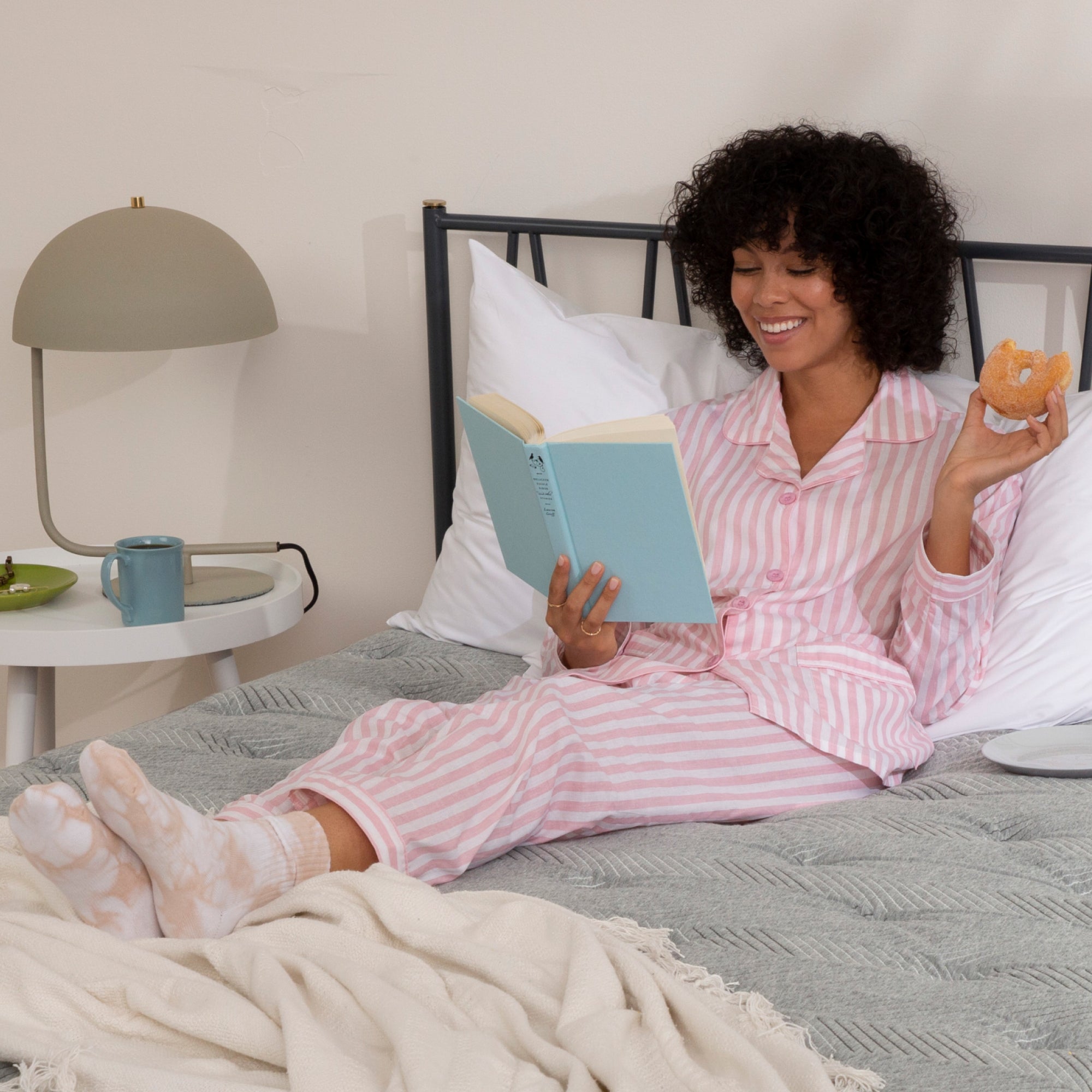 Women reading a book on a quilted plush mattress