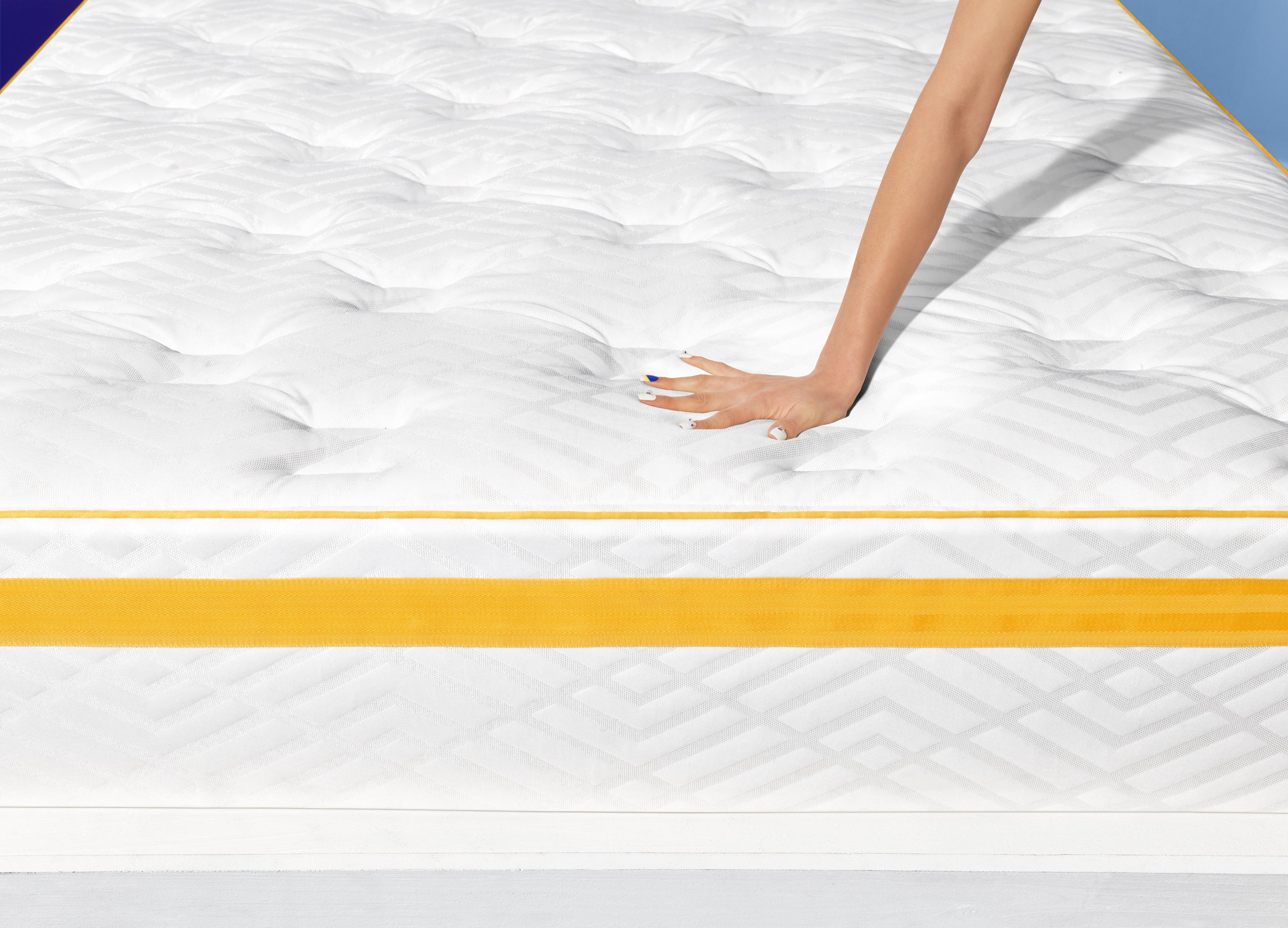 Hand pressing down on Hybrid - Plush Support mattress